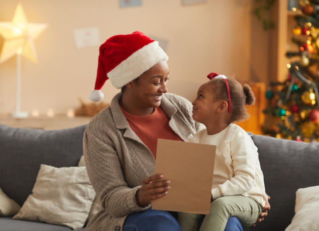 Mom reading letter from Santa to daugher